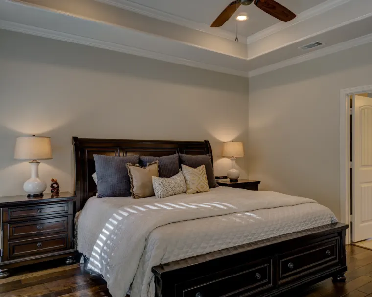 Main bedroom with a dark timber sleigh bed, matching pedestals and bedside lamps