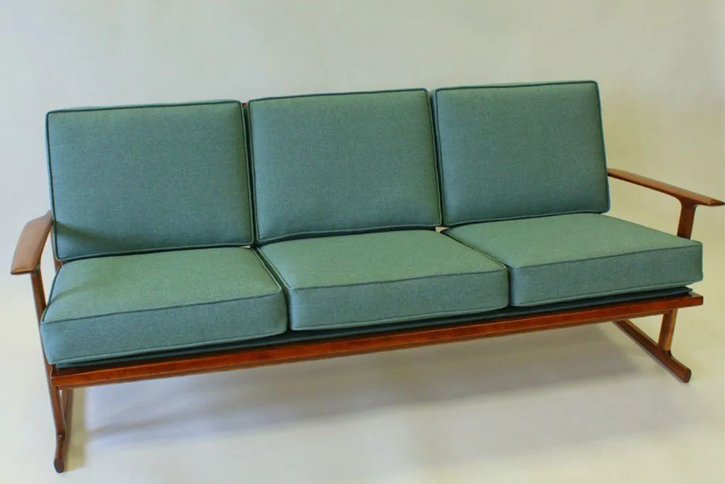 The same mid-century sofa restored and re-upholstered in teal wool fabric